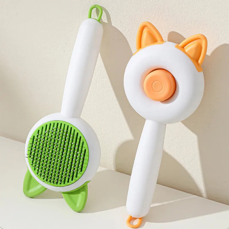 Greenish white and orange white self-cleaning cat comb with stainless steel bristles for pet hair removal.