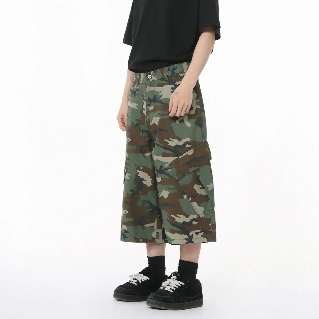 Men's cropped length camouflage cotton wide-leg jeans with large side pockets on a plain background.