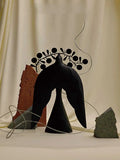 Handmade ancient Chinese style iron flying bird ornament on a wooden surface.