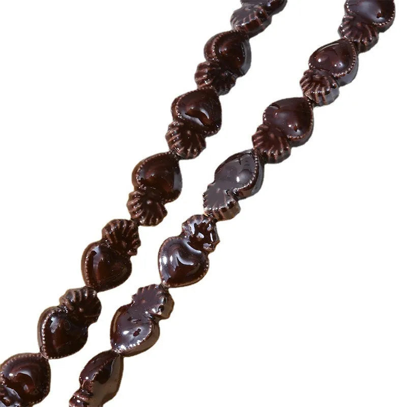 Small heart-shaped ceramic beads in multiple colours showing straight hole, approximately 10mm by 15mm size