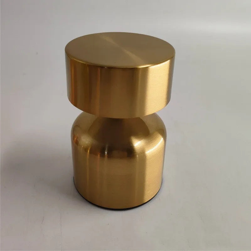 Mini retro dumbbell-shaped LED table lamp in metallic copper finish on a wooden desk