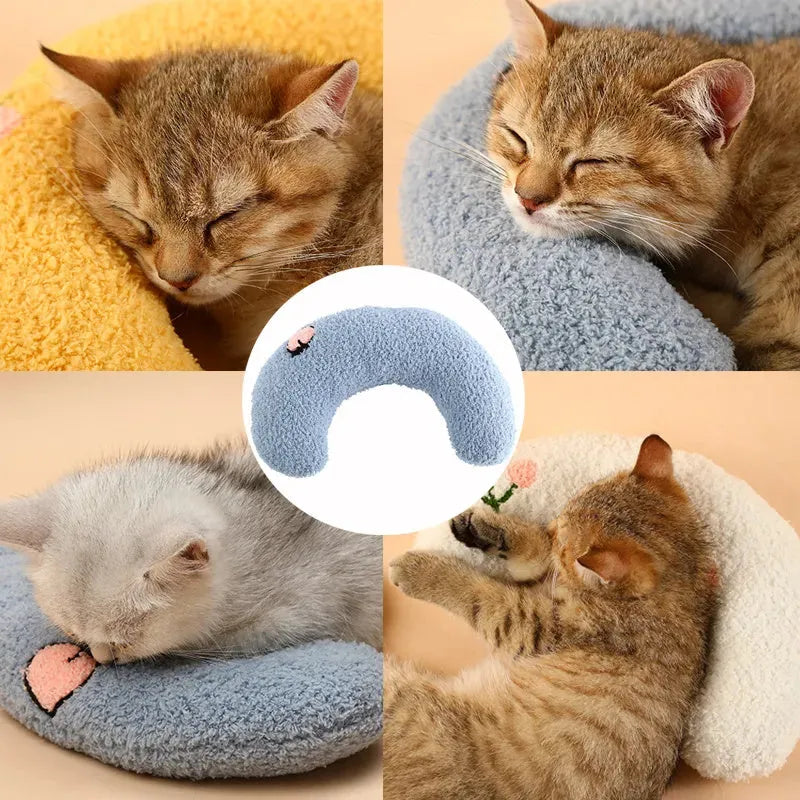 Plush white U-shaped pet pillow with raised rim for a cat or small dog to sleep curled up.