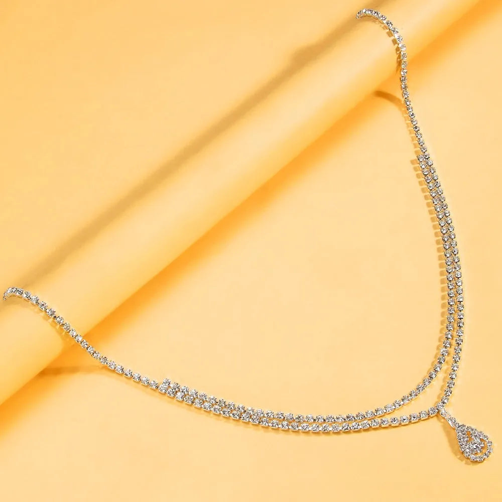 Gold or silver women's waist chain with water drop pendant and rhinestone tassel, showing lobster clasp.