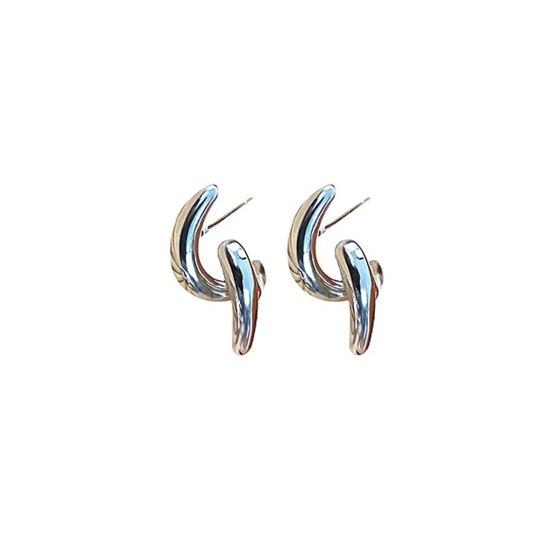 Women's textured line geometric copper stud earrings in silver and gold tones on neutral background