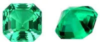 Selection of cultivated Columbia green emerald gemstones in various shapes and sizes on a white background.
