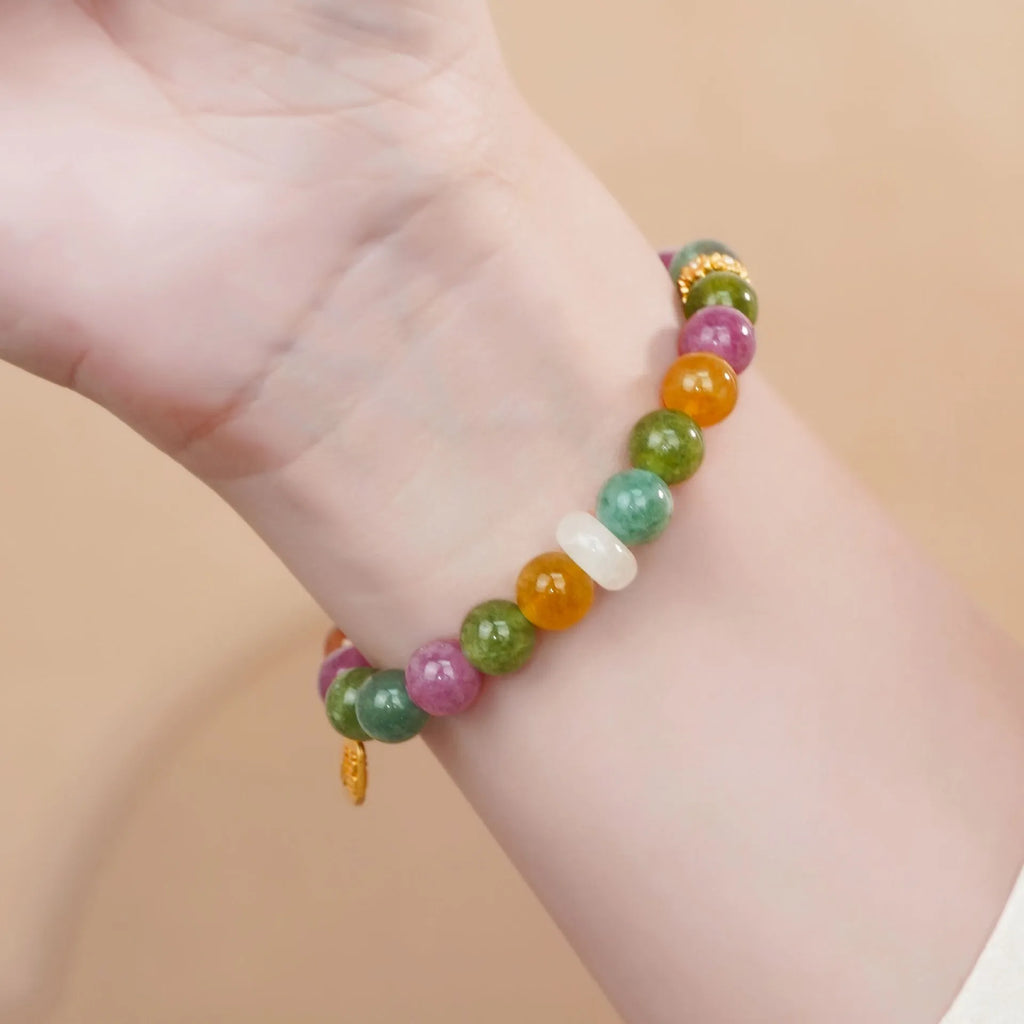 Natural rainbow-coloured tourmaline and jade half bracelet for women on a wrist.