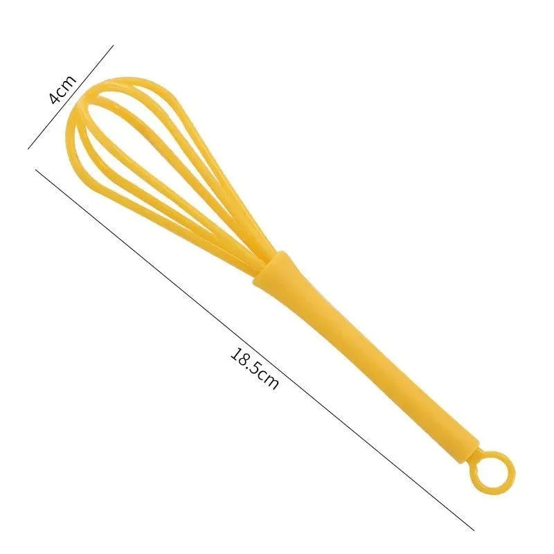Plastic mini manual eggbeater in green for stirring batter in a kitchen