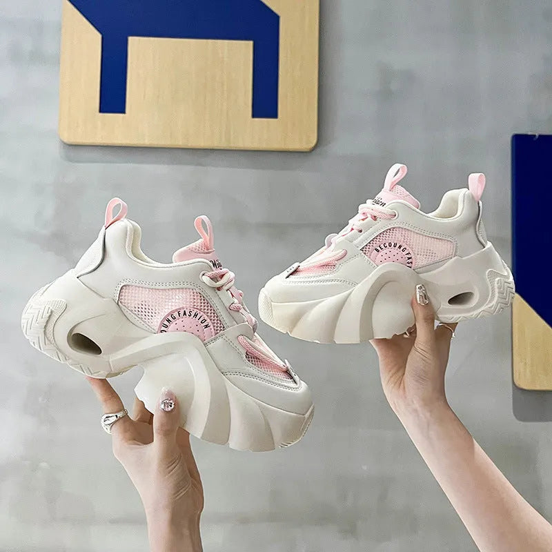 Women's beige sneakers with a thick rubber sole, cross ankle strap, and mesh lining.