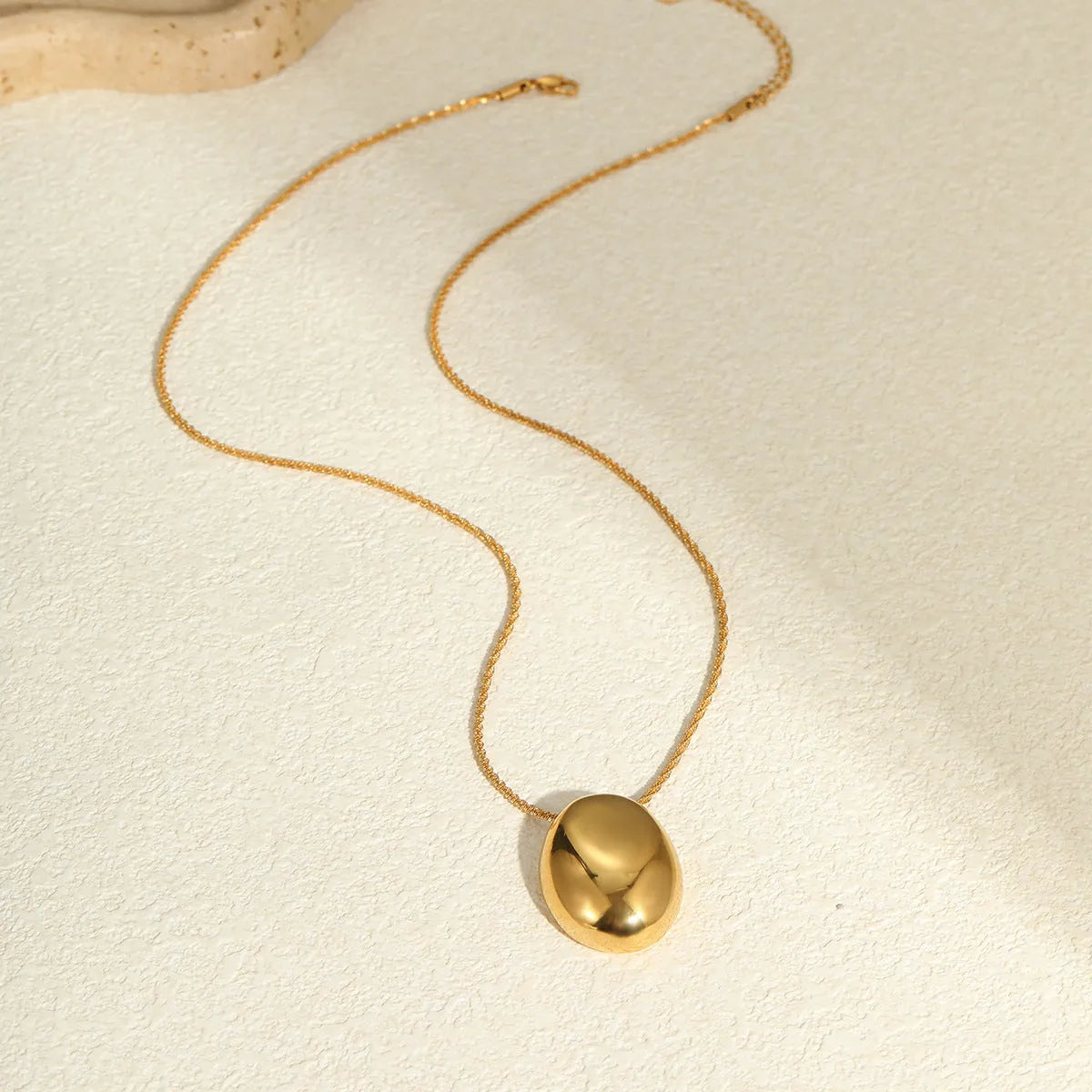 Gold geometric pendant necklace on adjustable stainless steel chain, shown at 41cm length.