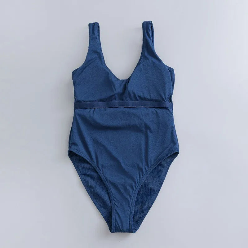Navy blue women's one-piece triangle swimsuit with chest pads on a mannequin, showing the sleeveless slimming design.