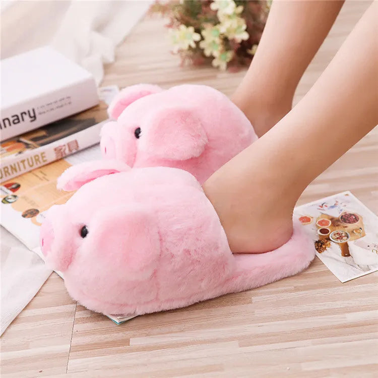 Pink pig-themed plush floor slippers for adults on a plain background.