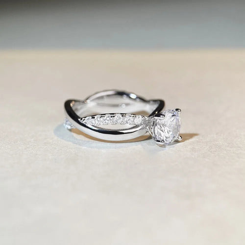 Geometric twisted silver band ring with a 1 karat moissanite stone in a four-claw setting.