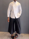 Women's white asymmetric long sleeve shirt and black pleated trousers co-ord set