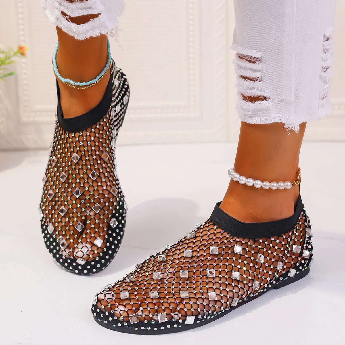 Colourful rhinestone detail on women's white mesh flat sandals with a round toe and rubber sole.