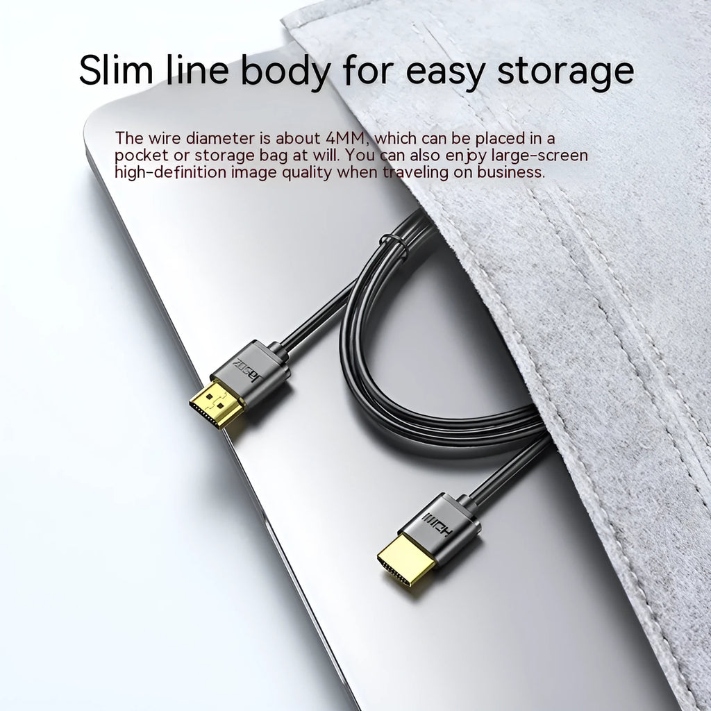 Close-up of a black HDMI cable with gold-plated connectors and a flexible cord on a grey background.