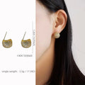Gold and white geometric drop-shaped clip-on earrings with full diamond sparkle and sphere details.