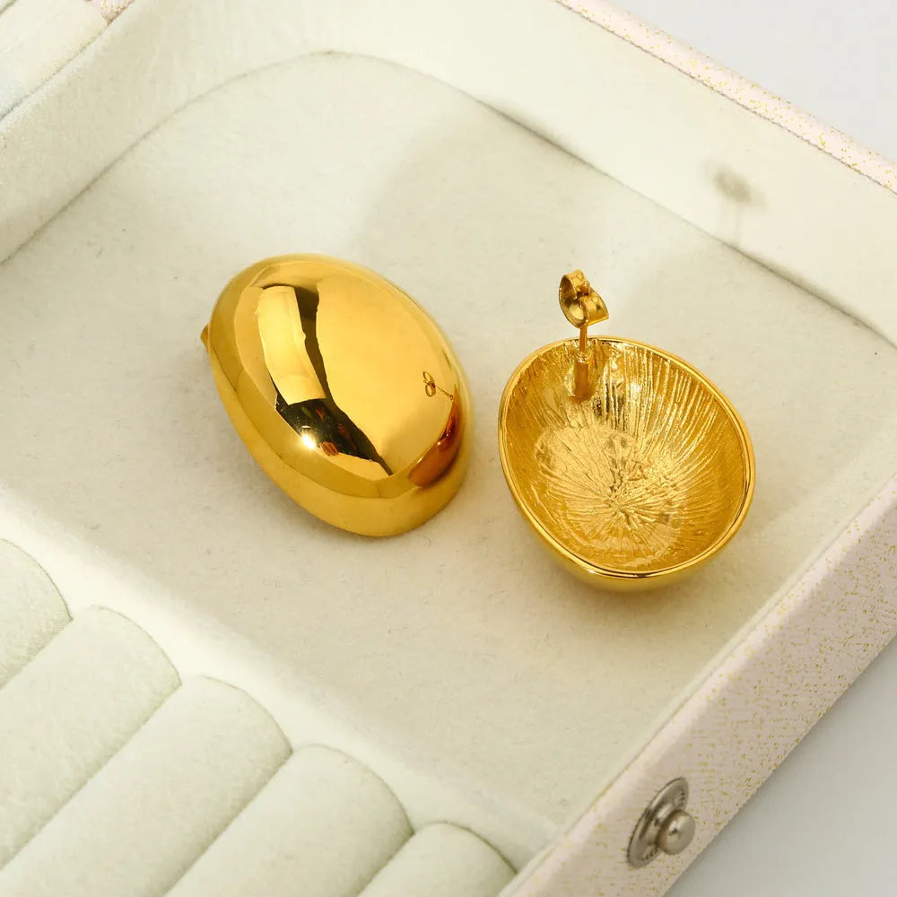A pair of geometric stainless steel ear studs with an 18K gold plated, glazed surface and line detailing.