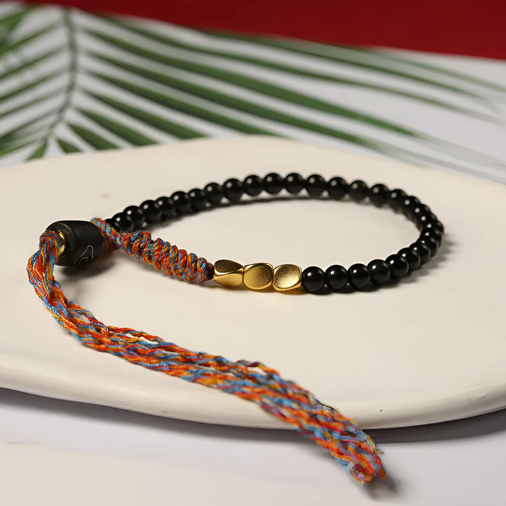 Slender dark obsidian hand-woven bracelet strap shown on a wrist