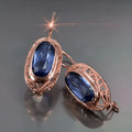 Women's copper and glass geometric earrings in red and blue with ellipse and ring shapes