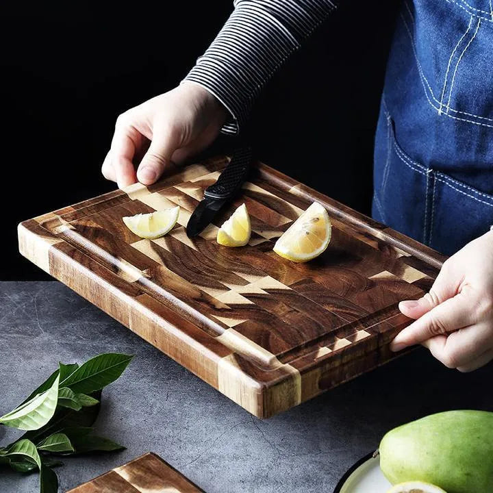 Brown solid wood chopping board with parquet pattern, shown on a kitchen countertop.