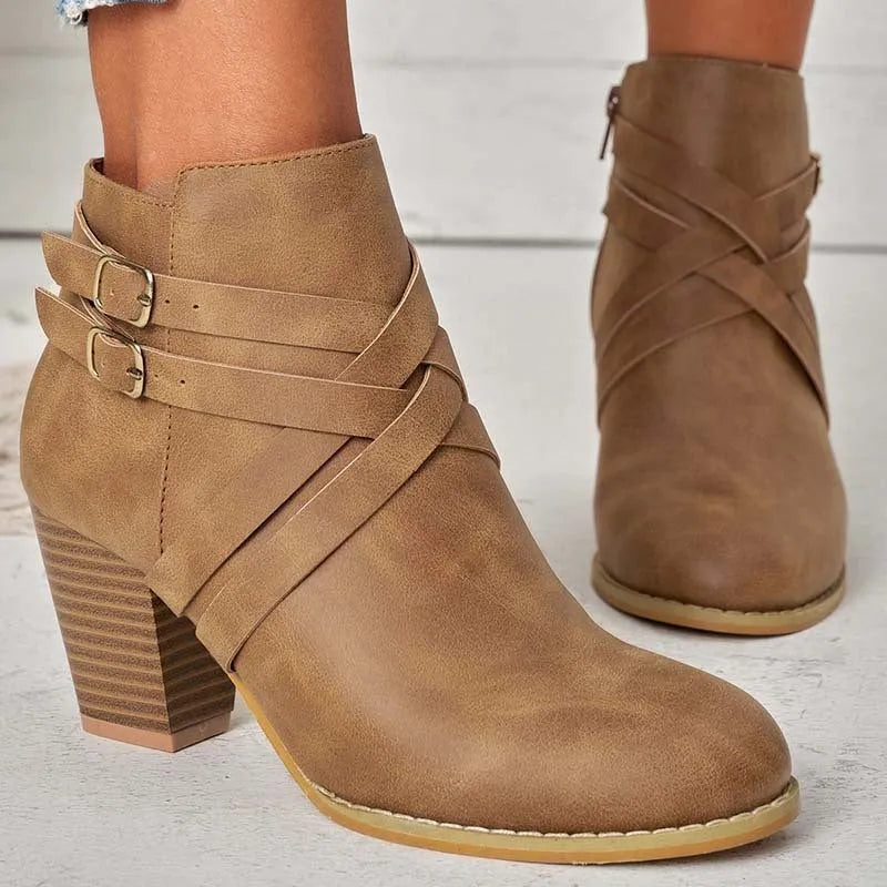 Plus size black short ankle boot with a 7cm heel, side zip, and buckle detail on a grey background.