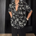 Loose black floral print short sleeve casual shirt on a hanger.
