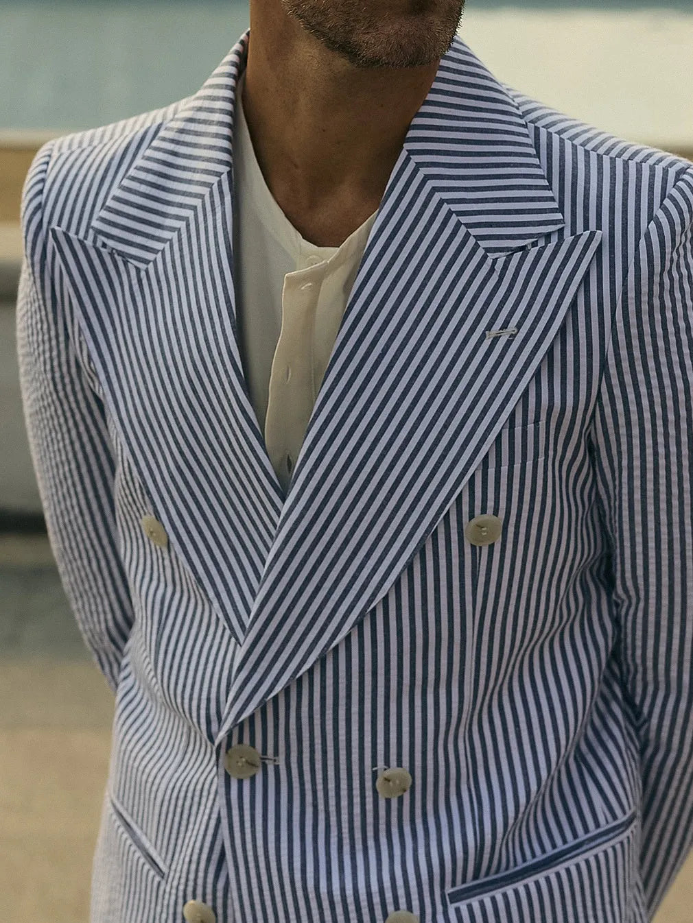 Blue and white striped polyester blazer and trousers suit set on a hanger