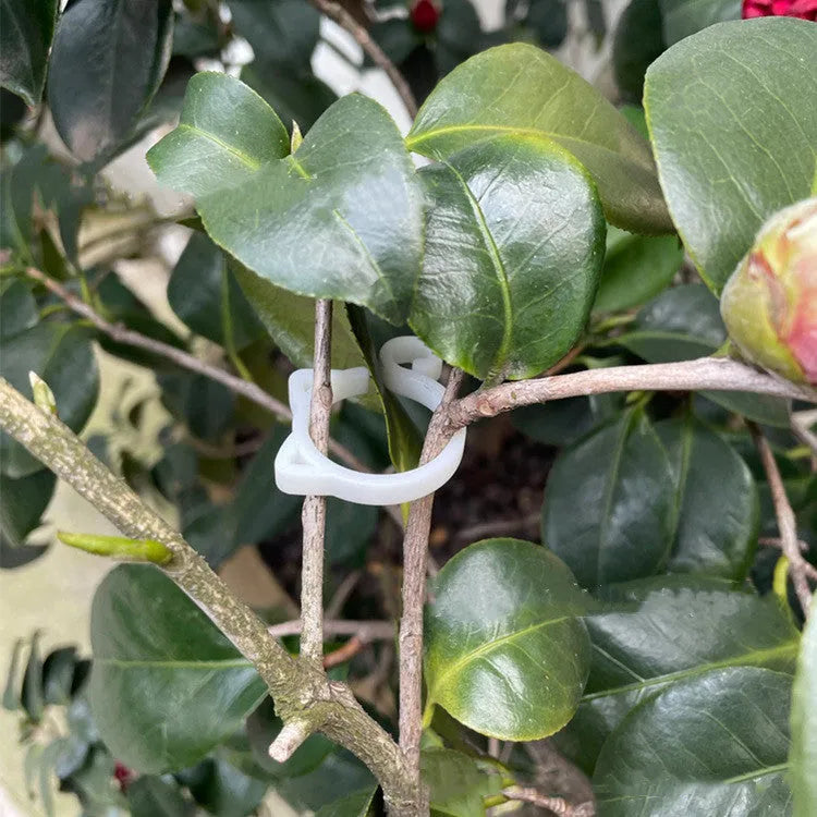 Decorative red cat-shaped plastic plant clip on a small green plant stem.