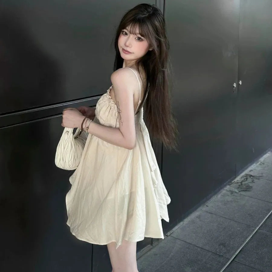 Apricot polyester sleeveless vest top with spaghetti straps, double-connector strap style, and asymmetric splicing detail.