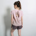 Ladies short sleeve polyester sports T-shirt in pink, shown on a hanger.