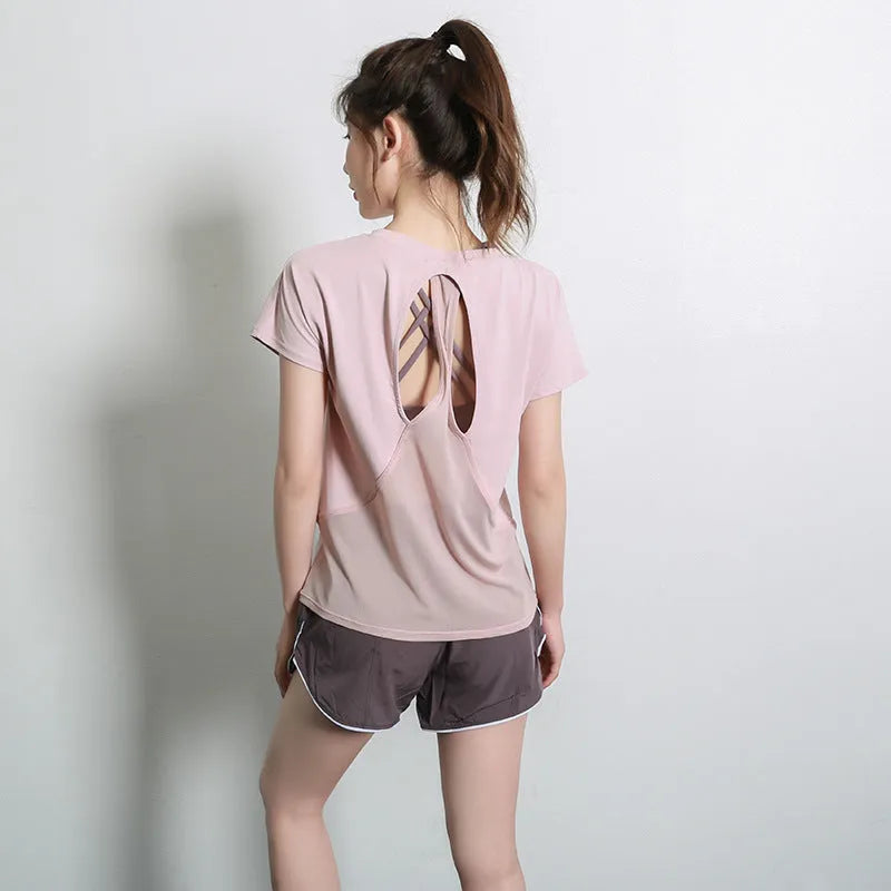 Ladies short sleeve polyester sports T-shirt in pink, shown on a hanger.