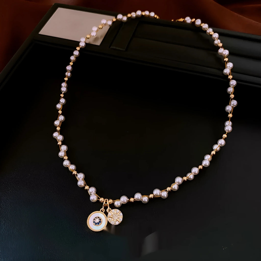 Gold-white electroplated necklace with round imitation pearl and zircon pendant on an adjustable clavicle chain.
