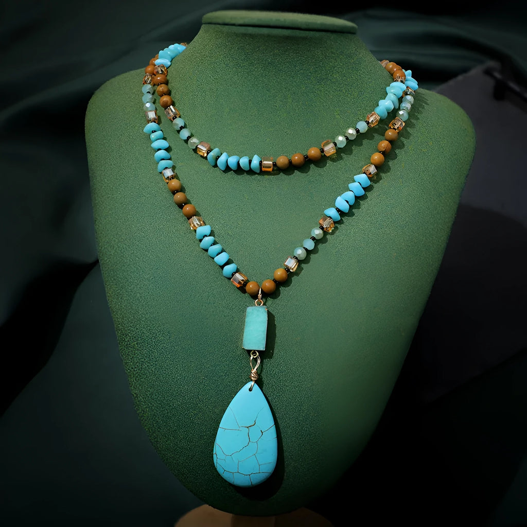 Turquoise blue large water drop pendant on a long mixed-material bead necklace.