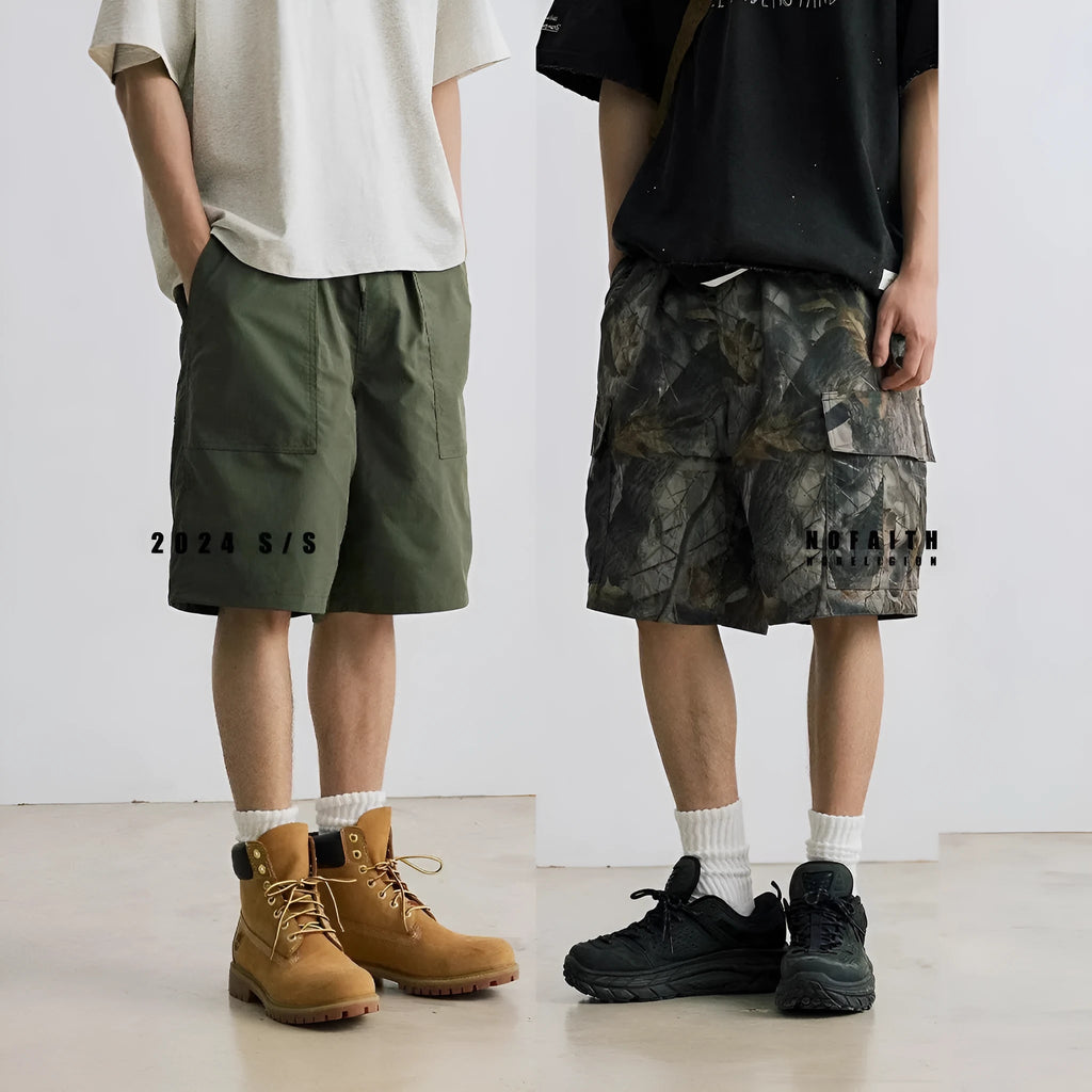 Loose fit straight-leg denim shorts in black or army green on a hanger, showing mid-waist and zip fly detail.