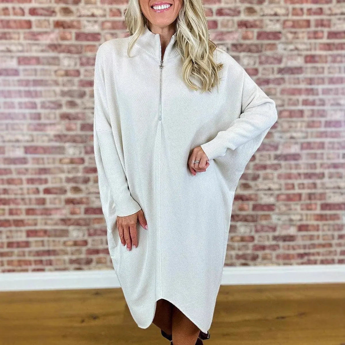 A women's solid colour loose knitted dress with raglan sleeves and a front zipper.