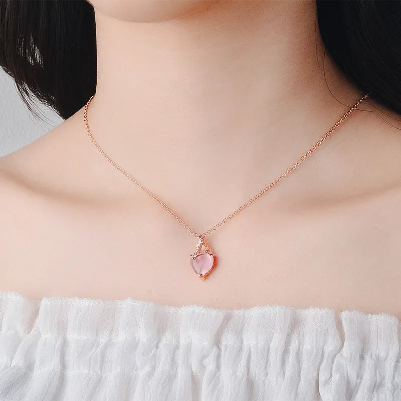 Rose gold women's necklace with heart-shaped pink crystal pendant on cross chain