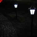 Outdoor solar hexagonal wall light in garden setting, available in white or yellow light, with ground plug or wall hanging style