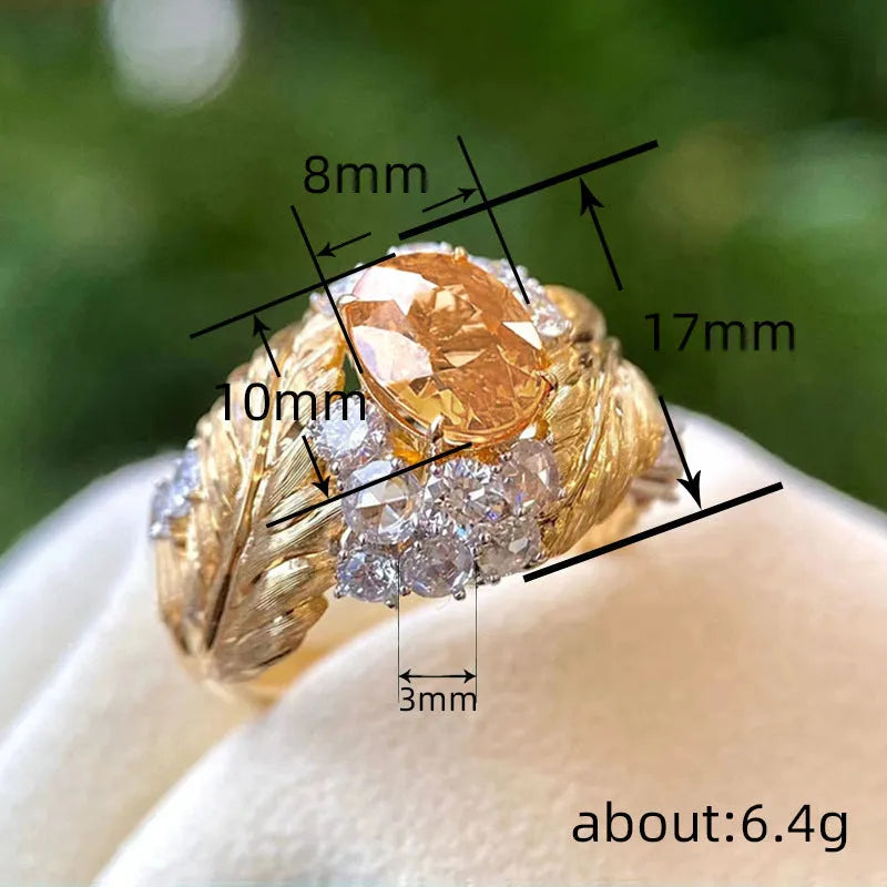 Gold-toned copper women's ring with an embossed feather design and a central yellow zircon stone.