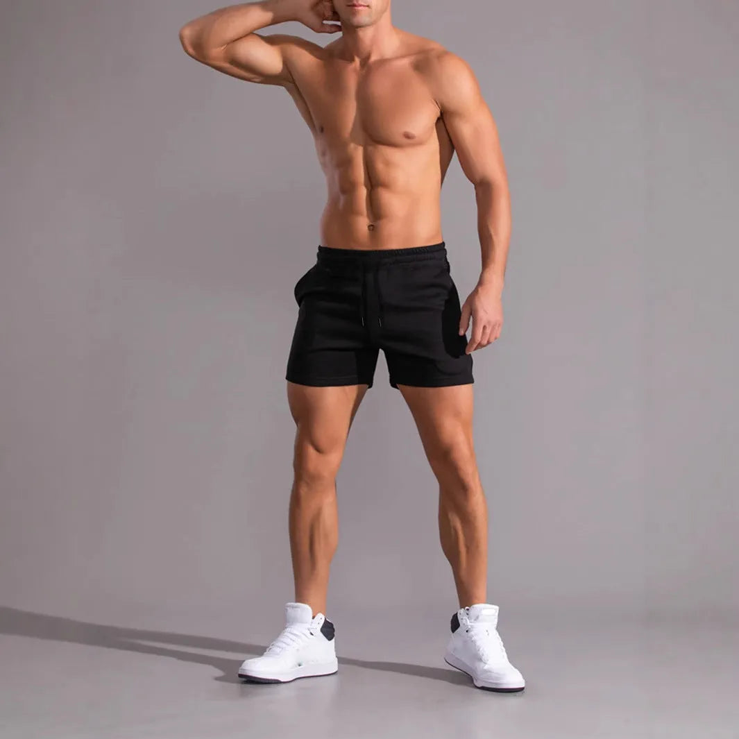 Pack of three men's solid colour drawstring shorts in loose fit on a plain background.