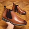Men's black formal leather pointed-toe boots with a square heel on a white background.