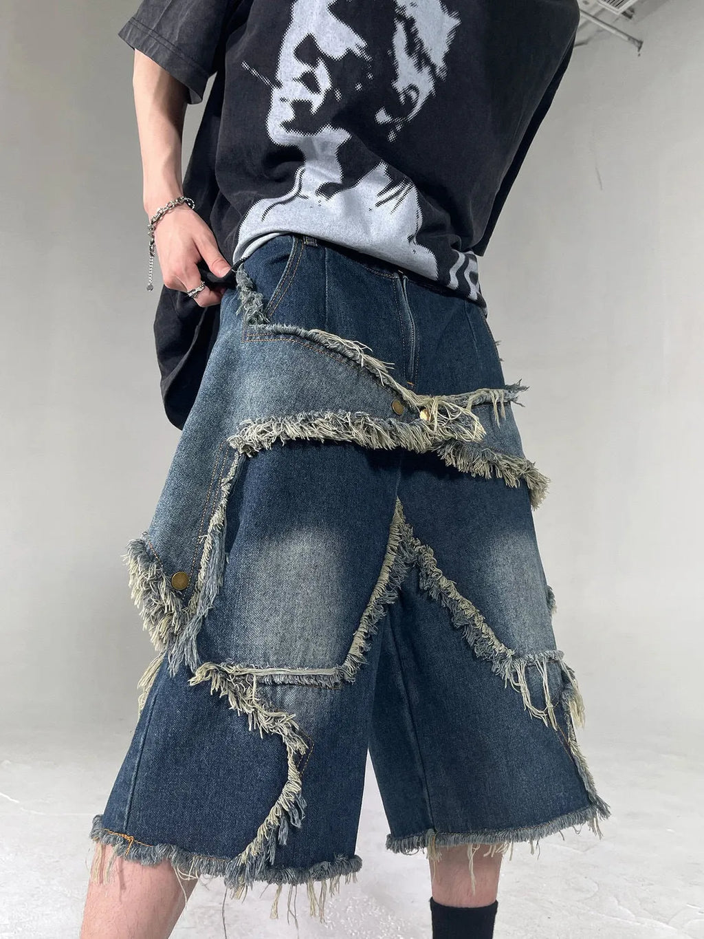 Blue denim shorts with distressed five-pointed star detailing and frayed hem, loose fit retro style
