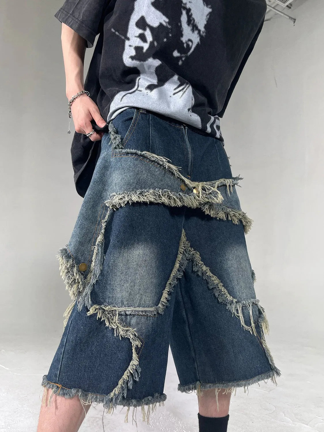 Blue denim shorts with distressed five-pointed star detailing and frayed hem, loose fit retro style