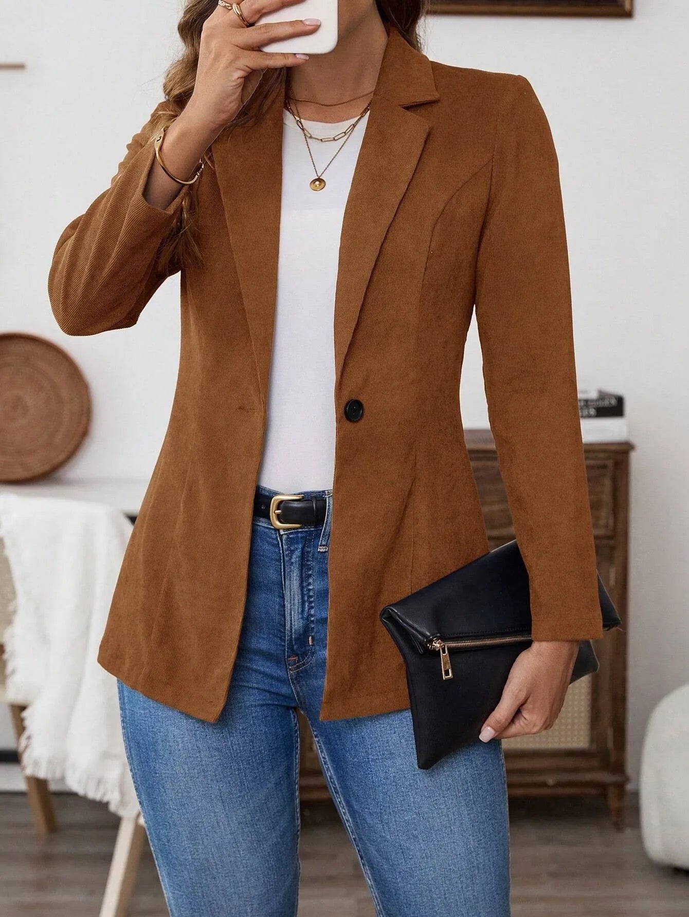 Brown men's single-breasted lapel blazer with long sleeves on a hanger.