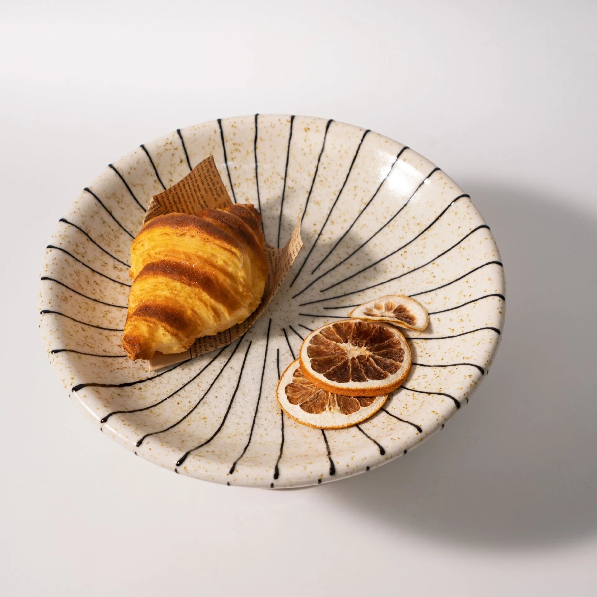 Black and white striped plastic resin fruit plate ornament, 16cm diameter, on a table.