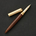 Brass sandalwood signature pen 14cm with wood barrel on a flat surface