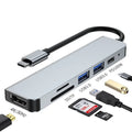 Portable silver 6-in-1 TYPE-C expansion dock with short attached cable for laptops and tablets.