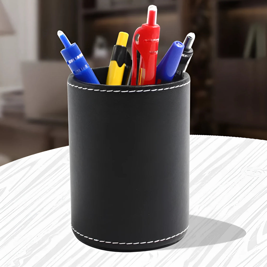 Small round black leather pen holder on a desk.