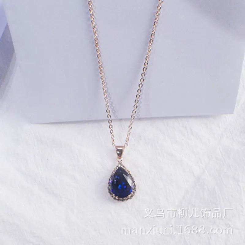 Close-up of a women's pink rose gold drop necklace with geometric rhinestone patterns on an alloy setting.