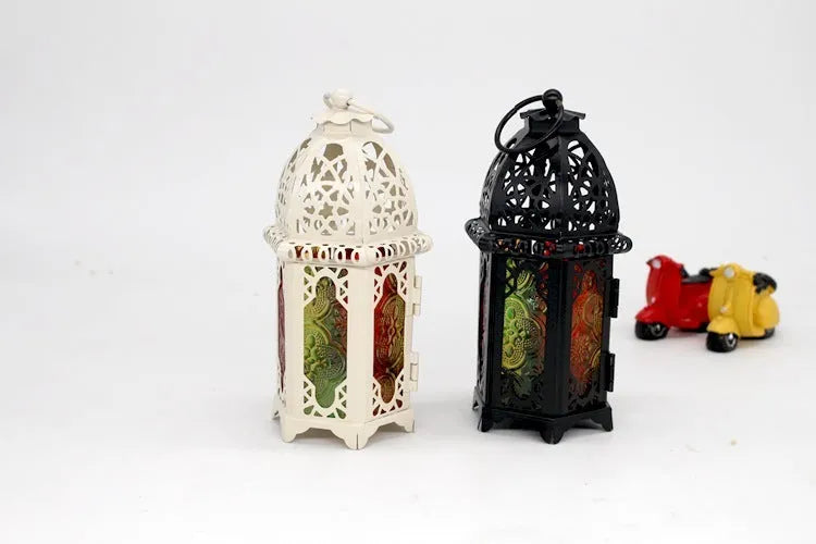 Handmade wrought iron hanging candle holder in black, 16cm tall and 7cm diameter, with a lit candle