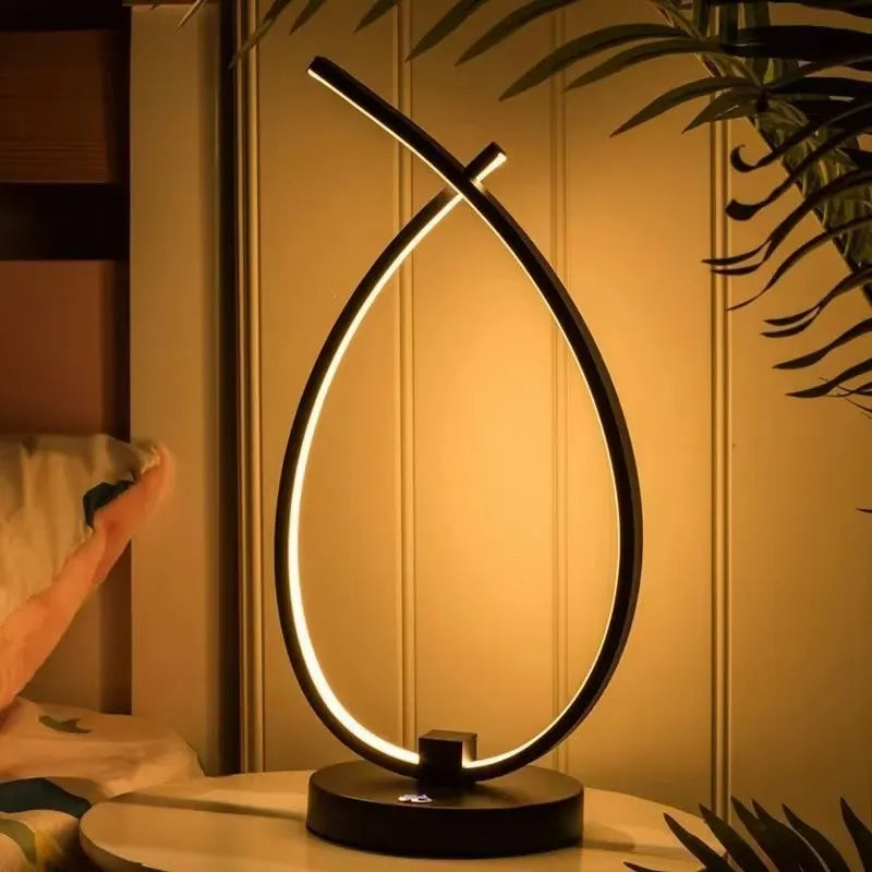 Black water drop shaped USB table lamp with touch control on wooden bedside table